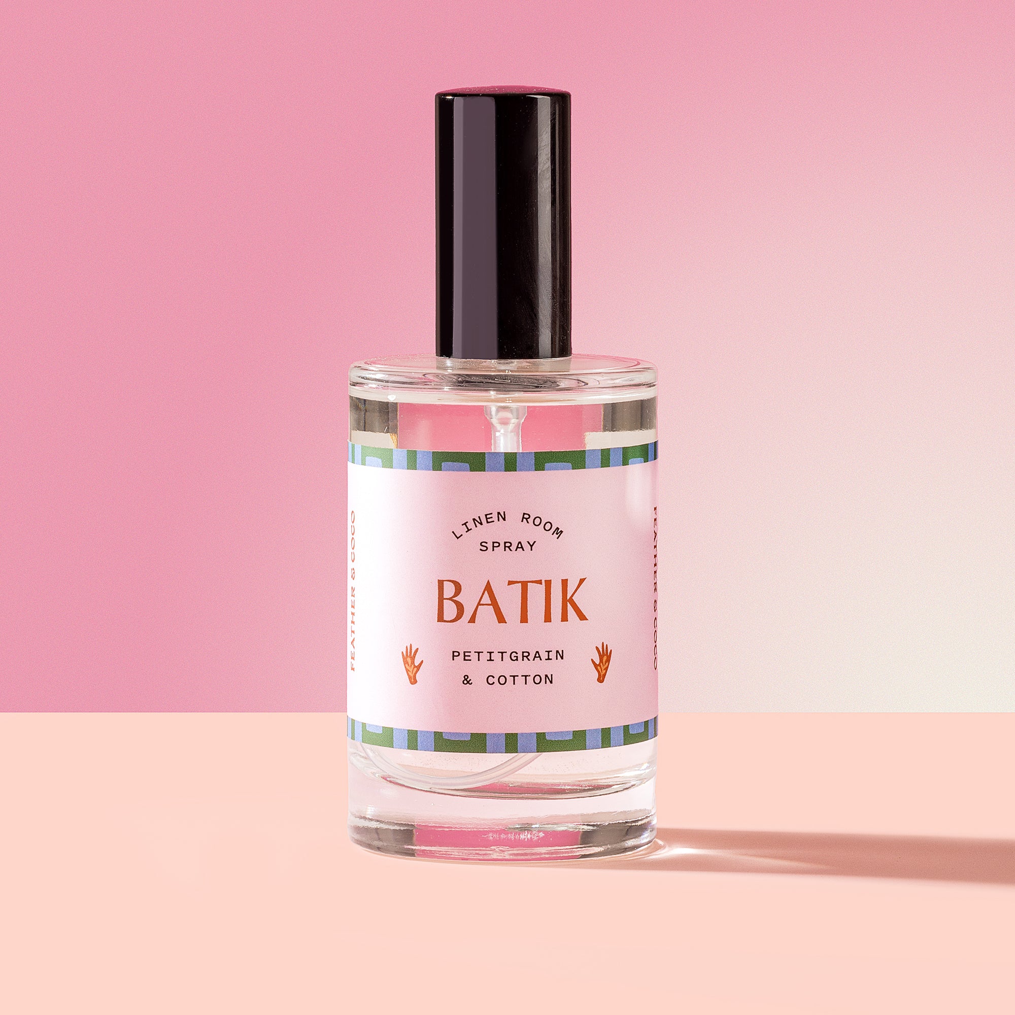 Batik Spray in a glass bottle on a pink background