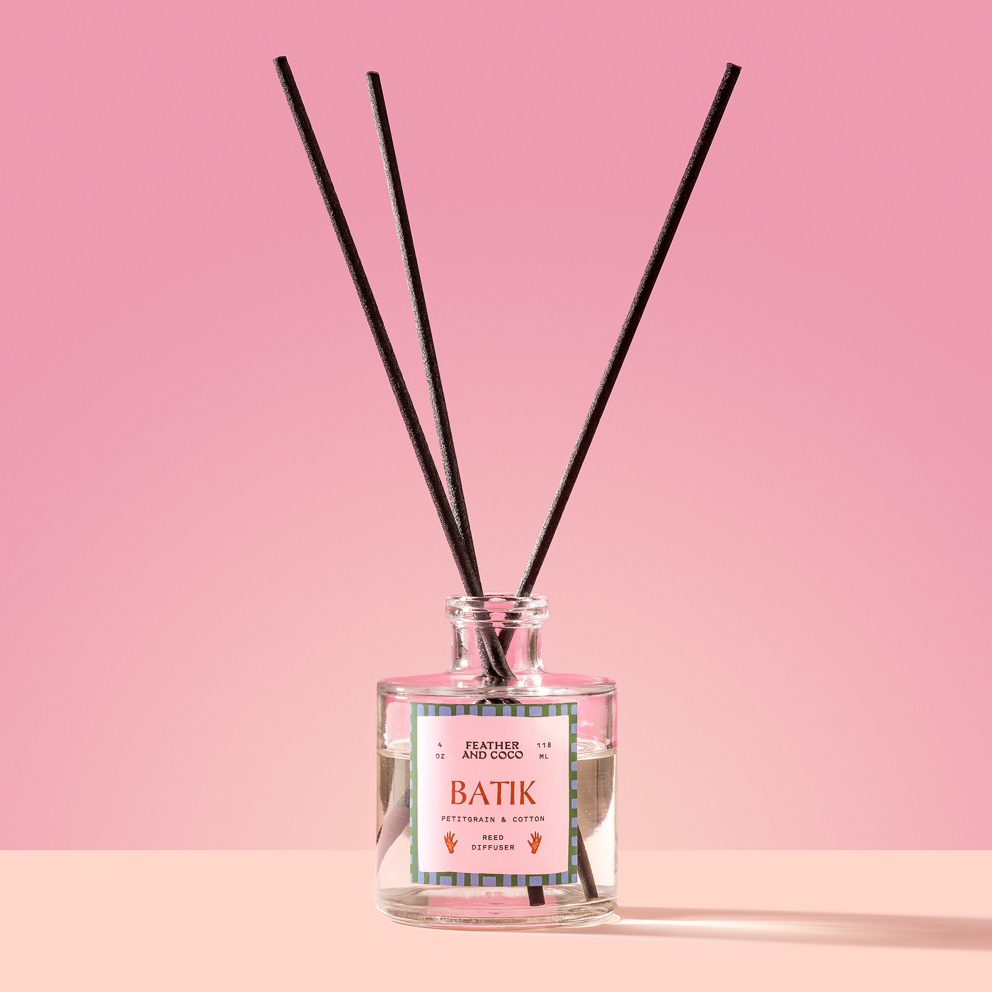 Batik Reed Diffuser in a glass bottle on a pink background