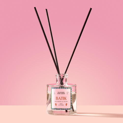 Batik Reed Diffuser in a glass bottle on a pink background