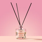 Boheme Reed Diffuser in a glass bottle on a pink background