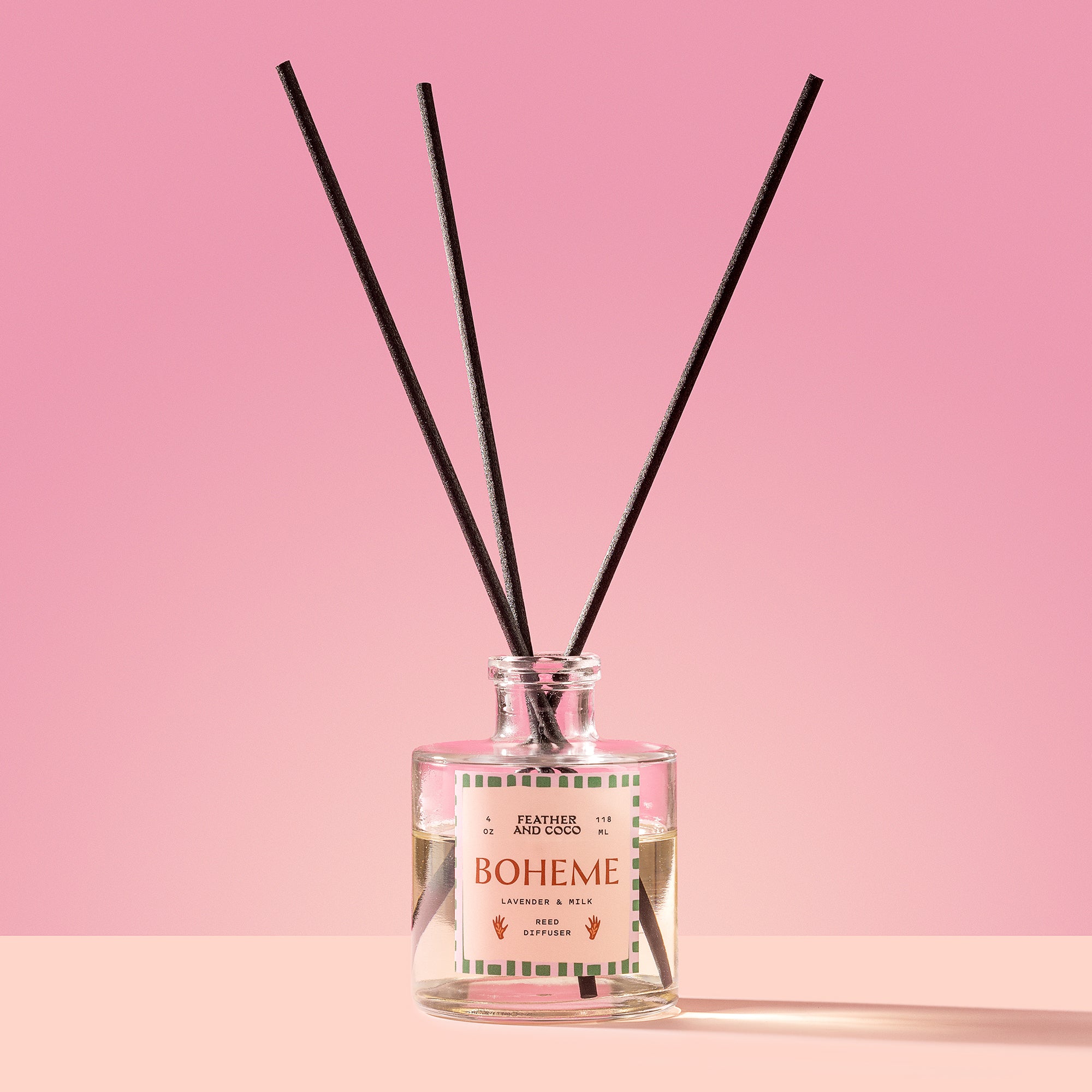 Boheme Reed Diffuser in a glass bottle on a pink background