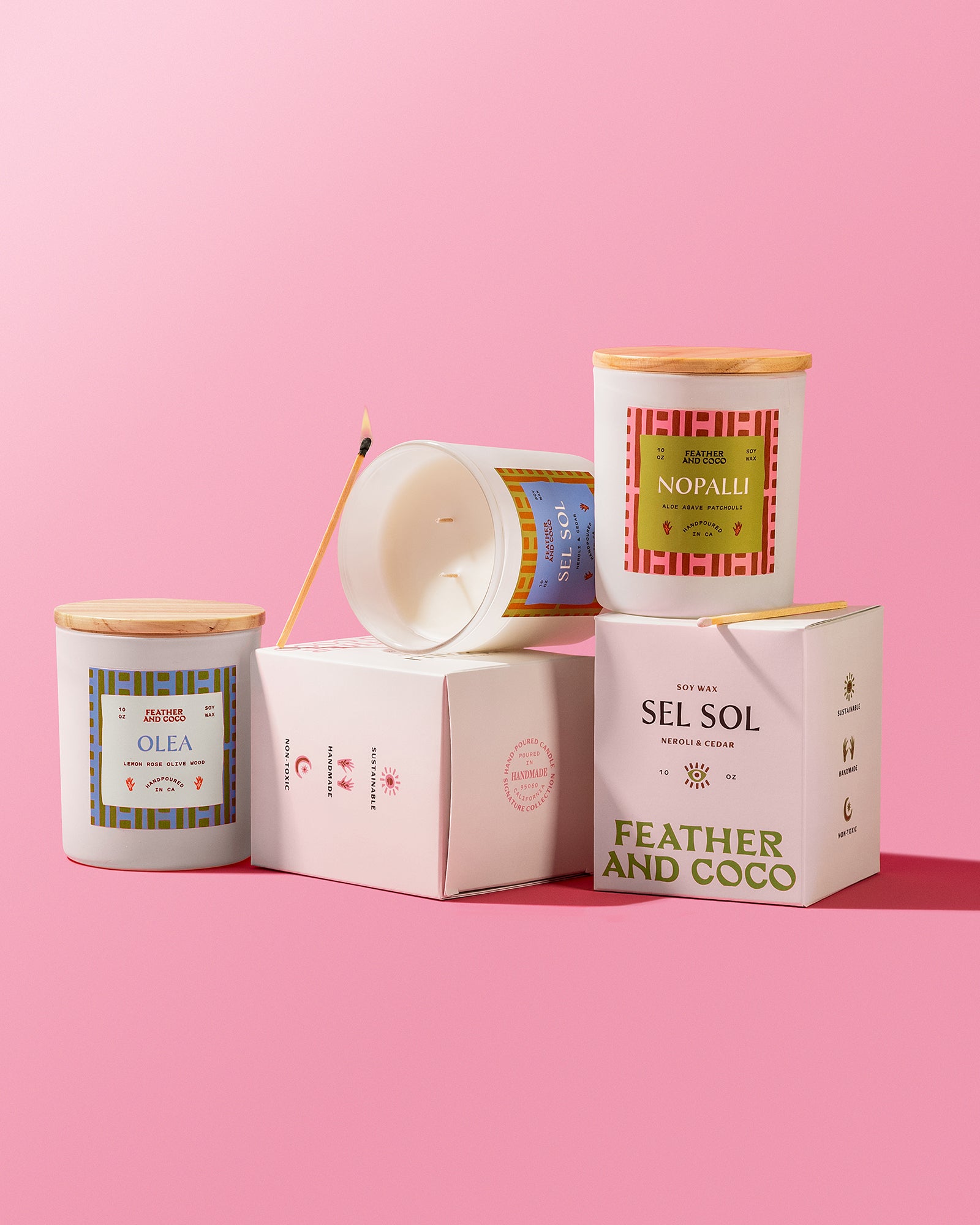 Candles and their packaging on a pink background
