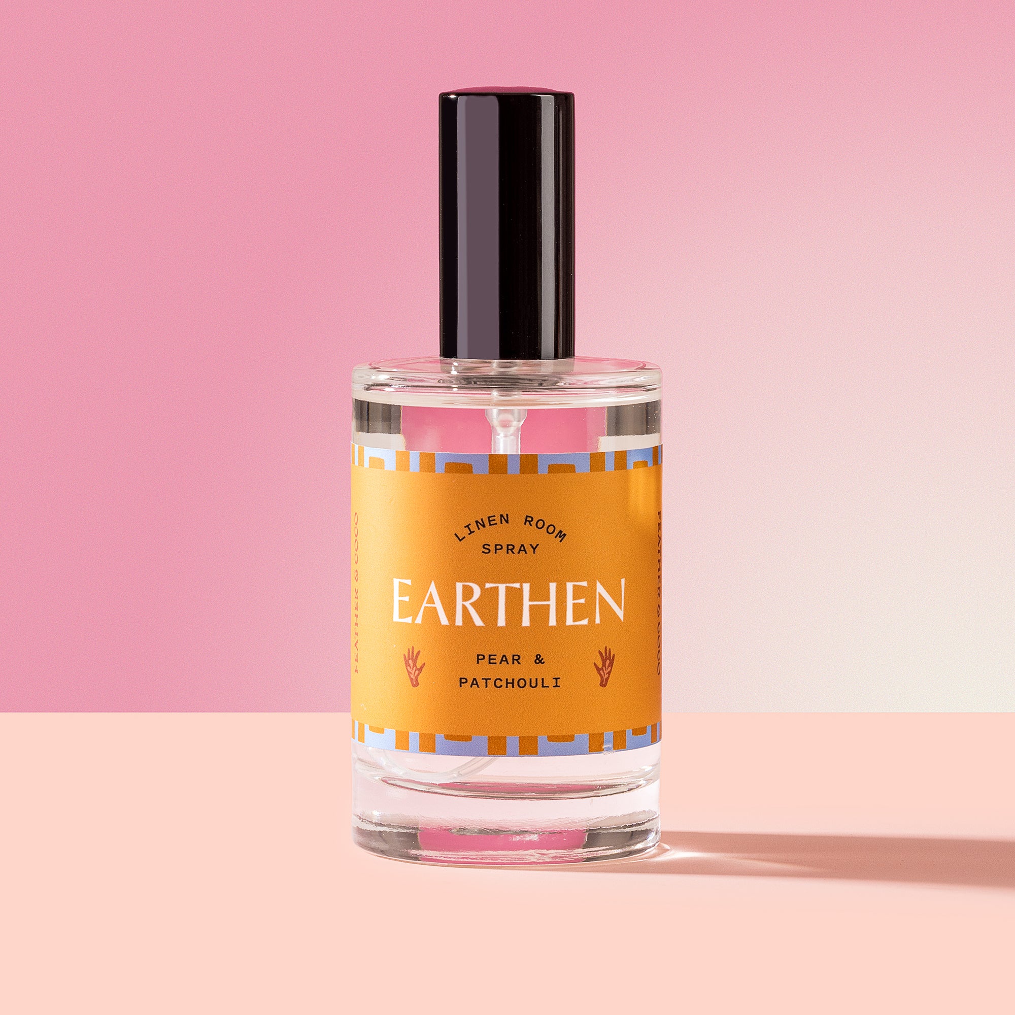 Earthen Spray in a glass bottle on a pink background