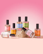 Collection of spray bottles with colorful labels on a pink background