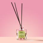 Nopalli Reed Diffuser in a glass bottle on a pink background