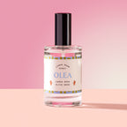 Olea Spray in a glass bottle on a pink background