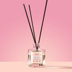 Olea Reed Diffuser in a glass bottle on a pink background