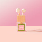 Selva Car Diffuser with wooden cap and pink label on a pink background